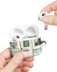 Pick Me Up At 8 Earbuds Case—Glossy polycarbonate shell featuring vintage travel watercolor camper and floral artwork, lightweight design, with clip attachment.