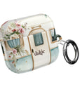 Pick Me Up At 8 Earbuds Case—Glossy polycarbonate shell featuring vintage travel watercolor camper and floral artwork, lightweight design, with clip attachment.